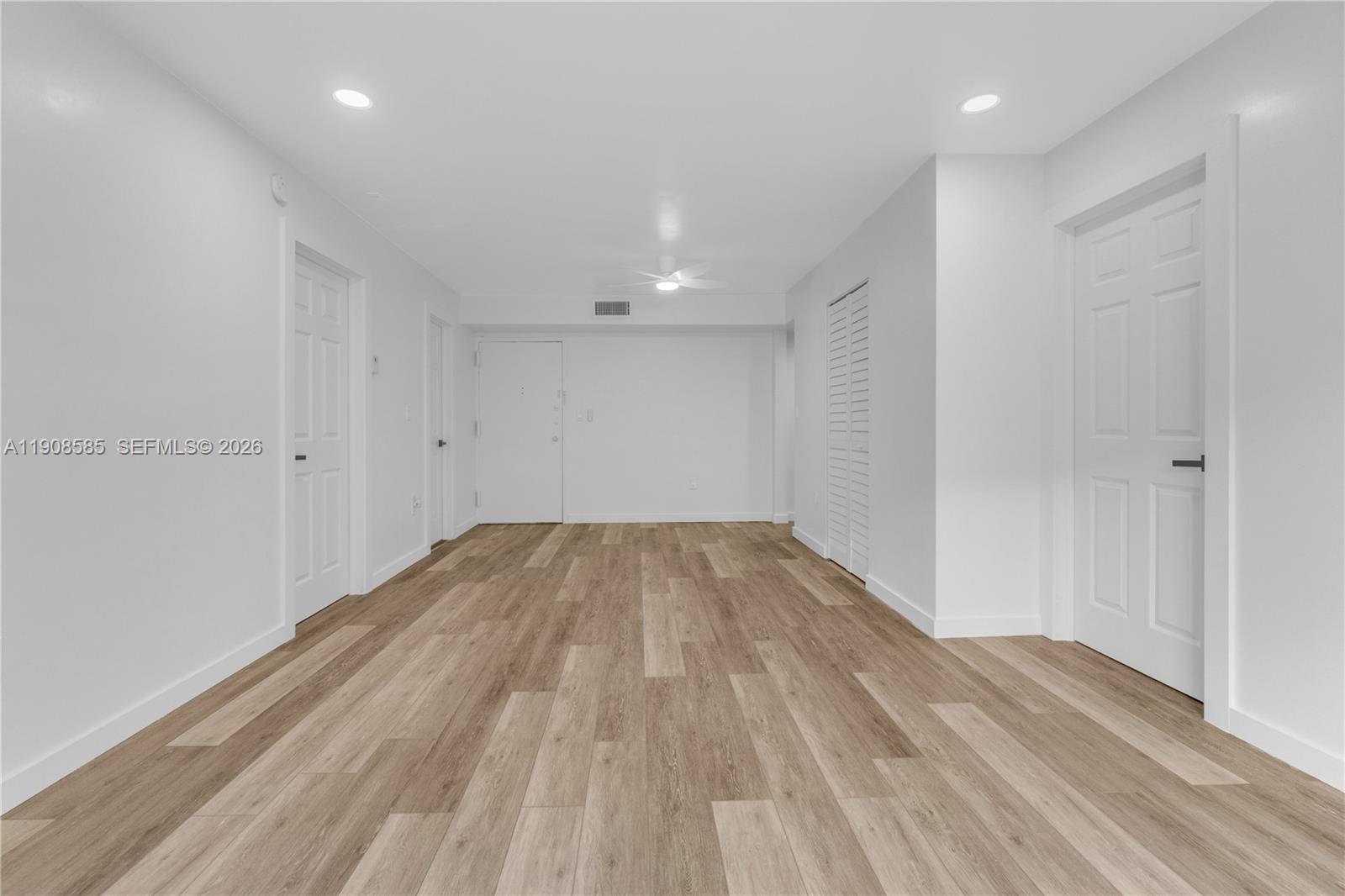 This room features light wood-look flooring, white walls, recessed lighting, and several closed doors — 4709 NW 7th St # 9, Miami FL 33126, MIAMI, FL