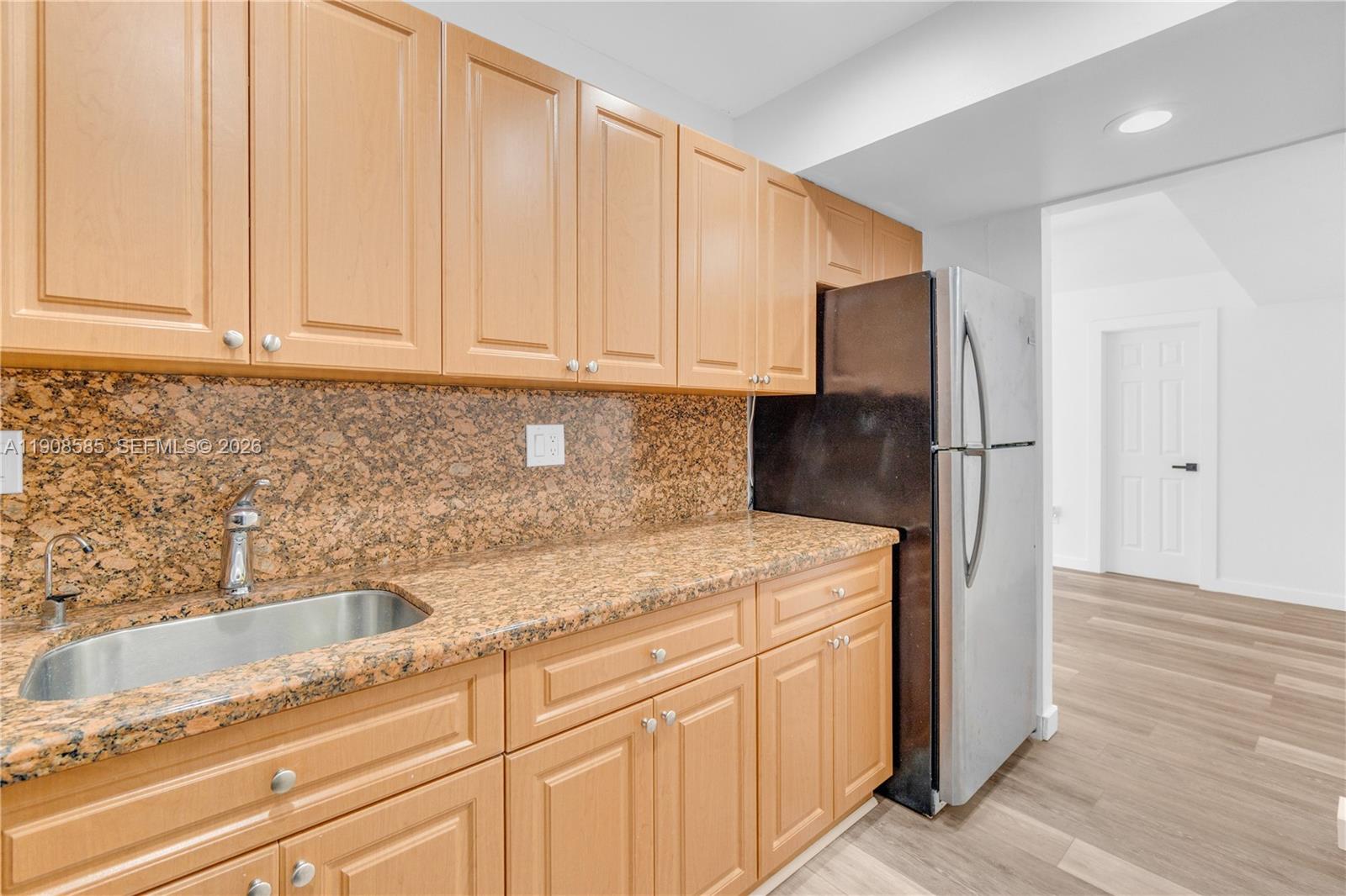 A kitchen features light wood cabinets, granite countertops, a stainless steel sink, and a refrigerator — 4709 NW 7th St # 9, Miami FL 33126, MIAMI, FL