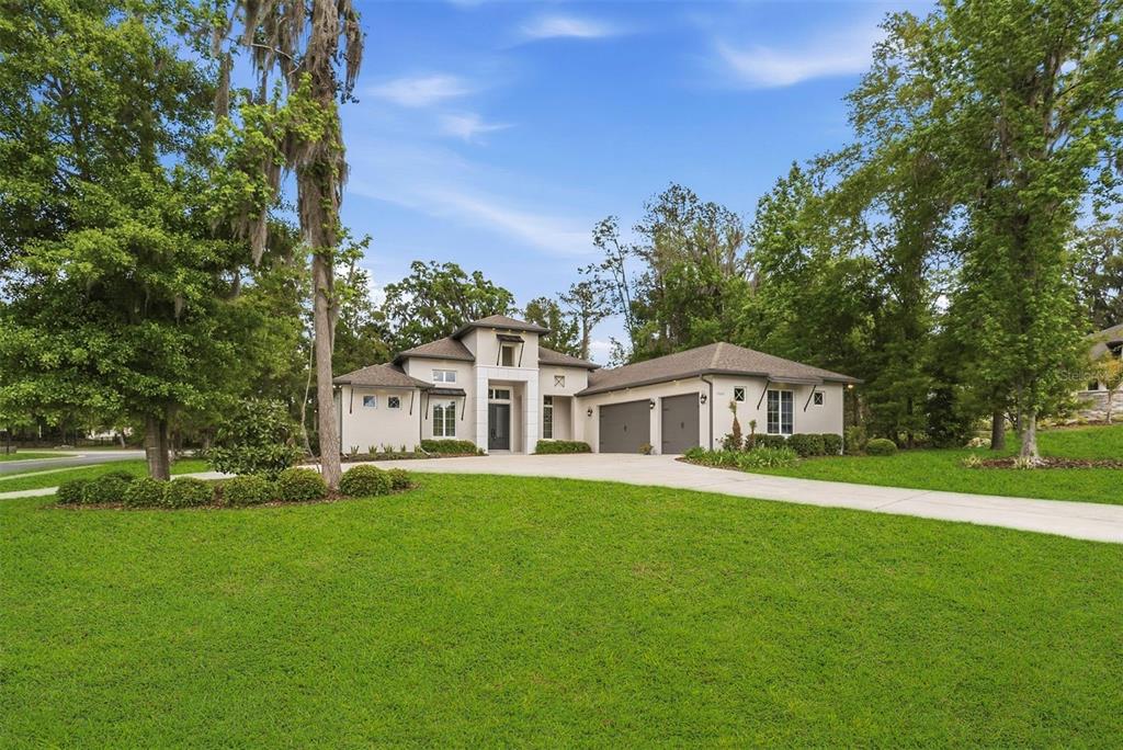 A two-story house with a light-colored exterior, a concrete driveway, and a two-car garage — 1003 SE 46TH STREET, OCALA, FL