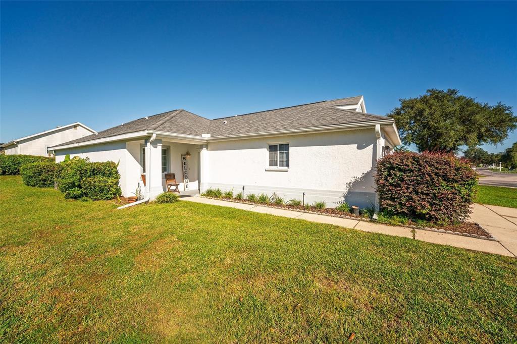A single-story house with a white stucco exterior, a gray roof, and a front walkway — 2048 NW 50TH AVENUE, OCALA, FL