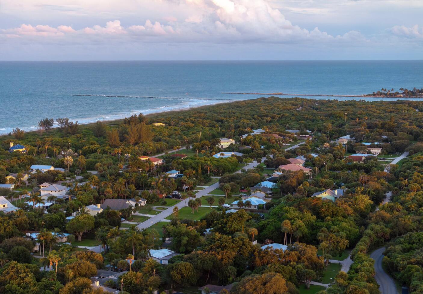 An aerial view of a coastal neighborhood surrounded by dense trees near the ocean — 2309 Atlantic Beach Boulevard, Fort Pierce FL 34949, FORT PIERCE, FL