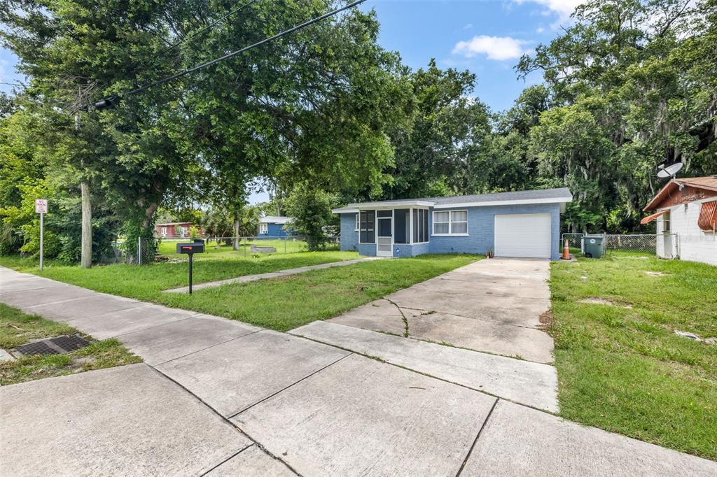 A blue single-story house with a screened-in porch, a garage, and a concrete driveway — 906 MAGNOLIA AVENUE, DAYTONA BEACH, FL