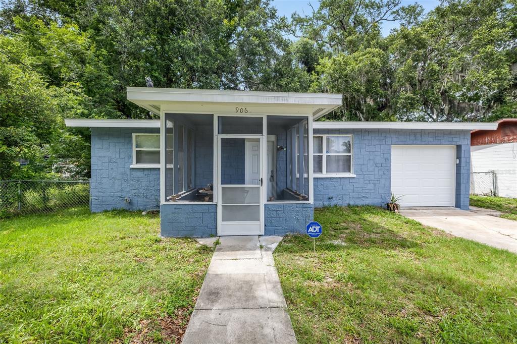 A blue, single-story house with a screened-in front porch and an attached one-car garage — 906 MAGNOLIA AVENUE, DAYTONA BEACH, FL
