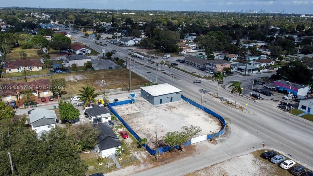 An aerial view shows a fenced vacant lot with a small building next to a road — 8248 NW 22nd Ave, Miami FL 33147, MIAMI, FL