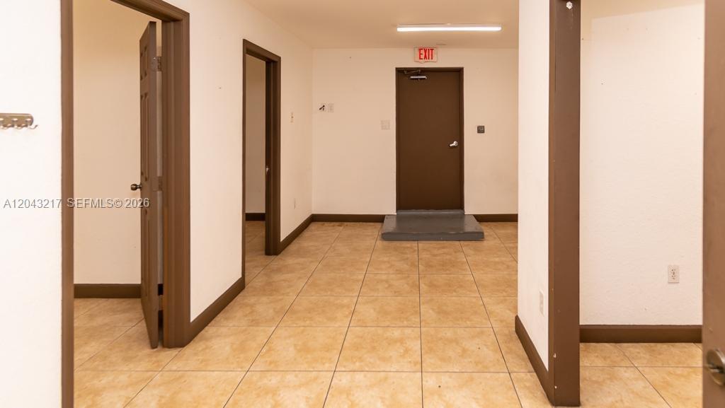 An interior view shows a tiled hallway with three doorways and an exit door — 8248 NW 22nd Ave, Miami FL 33147, MIAMI, FL