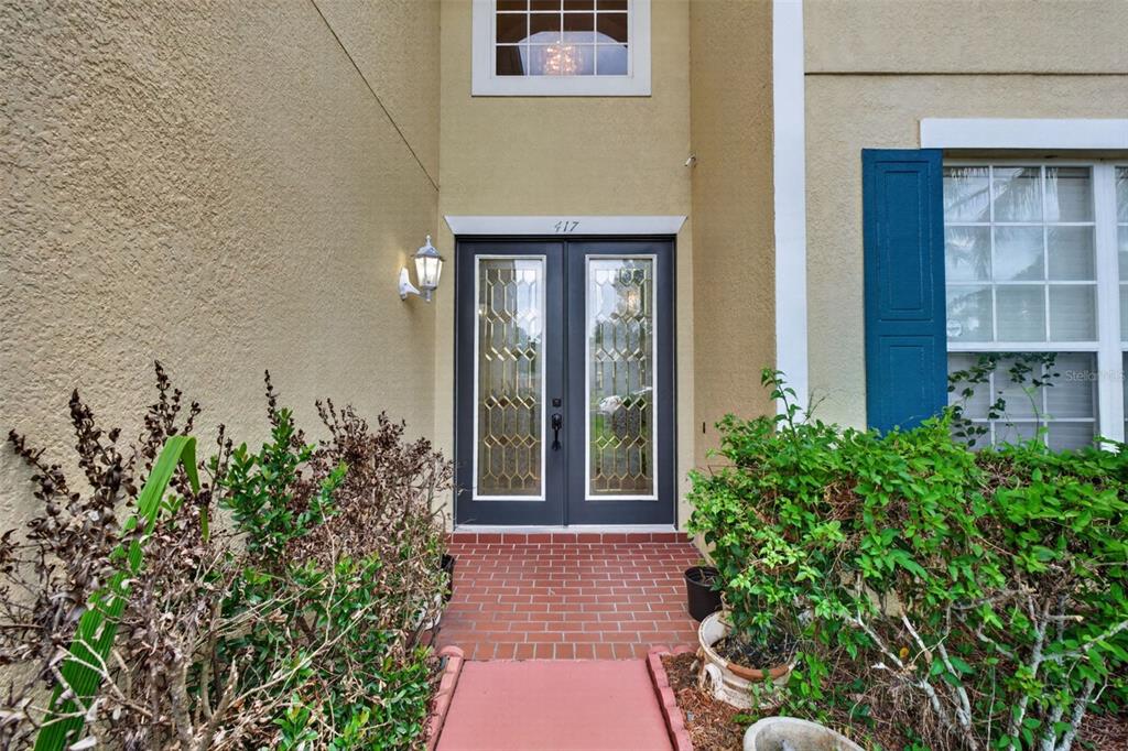 A front entrance features double glass-paneled doors, a brick walkway, and a small transom window — 417 KEHOE BOULEVARD, ORLANDO, FL
