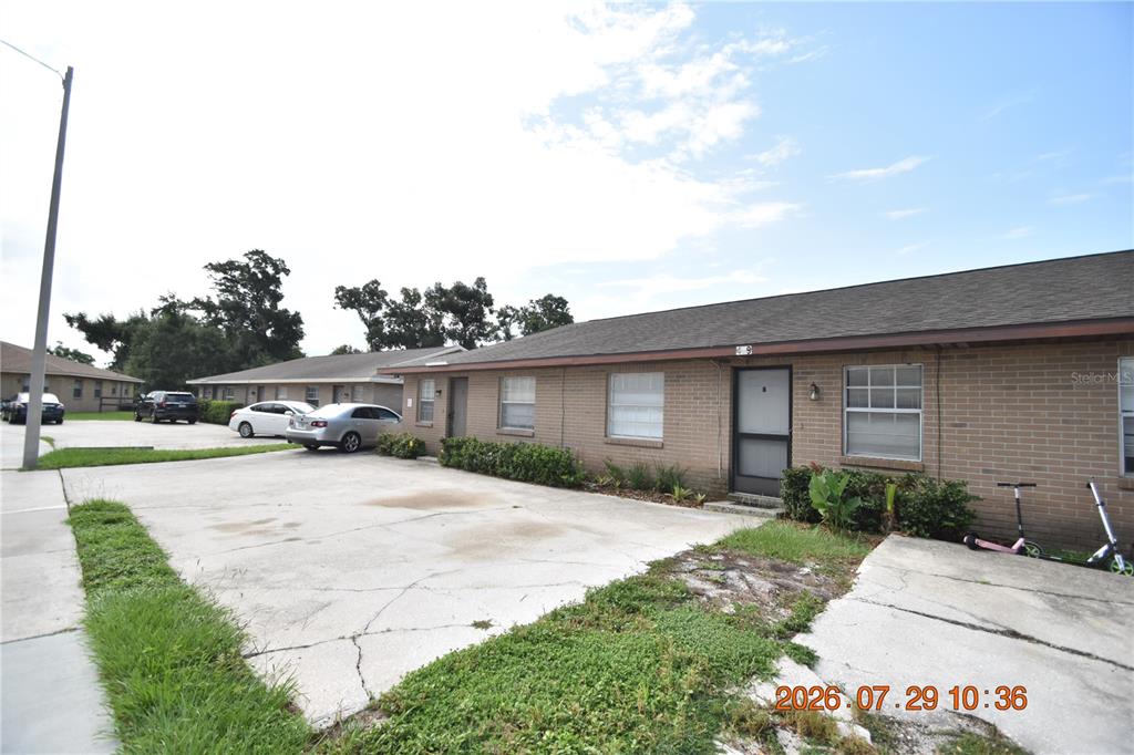 A single-story brick apartment building with a concrete parking area in front — 409 BIG CEDAR WAY UNIT B, BRANDON, FL