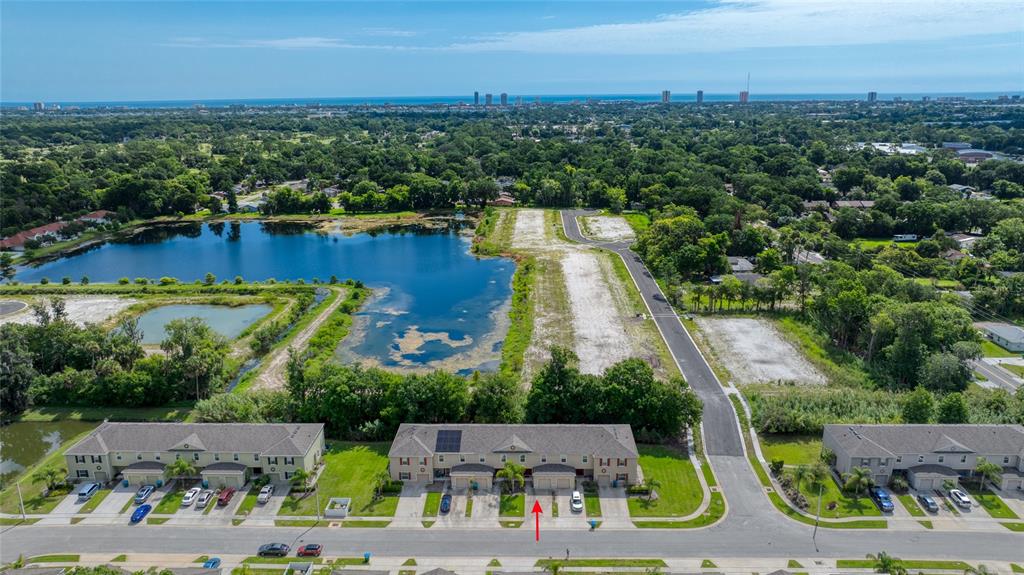 An aerial view shows a row of townhomes situated next to a large pond — 1615 PRIMO COURT, DAYTONA BEACH, FL