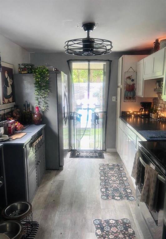 A kitchen features gray cabinets, stainless steel appliances, a ceiling fan, and a back door — 280 E 1ST STREET, APOPKA, FL