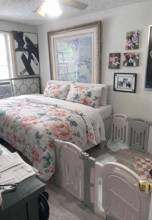 A bedroom features a floral-patterned bed, a large framed print, and a plastic playpen enclosure — 280 E 1ST STREET, APOPKA, FL