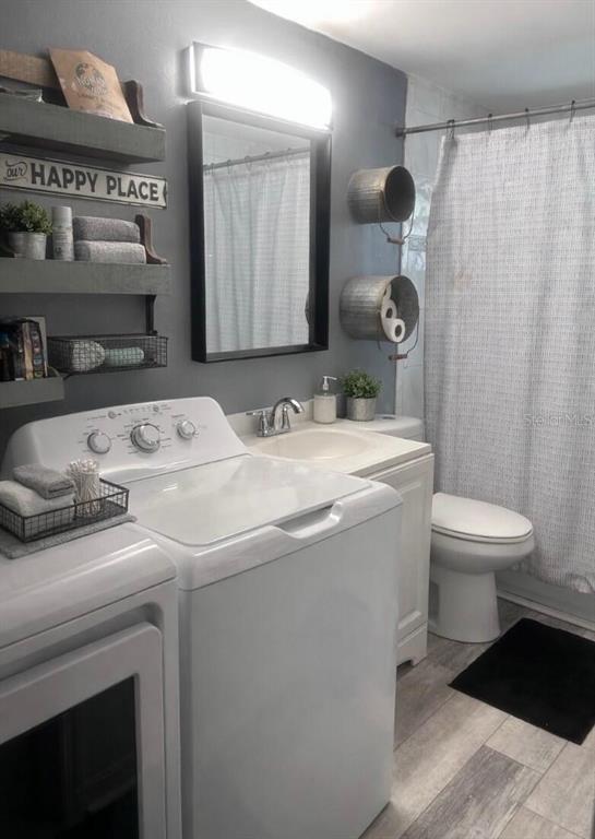 A bathroom featuring a laundry area with a washer, a vanity, and a shower curtain — 280 E 1ST STREET, APOPKA, FL