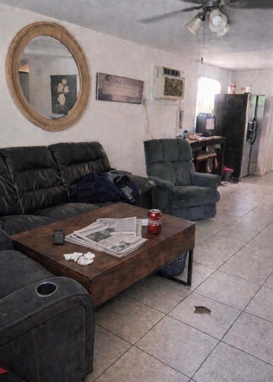 A living room features a dark sofa, a recliner, a coffee table, and tile flooring — 280 E 1ST STREET, APOPKA, FL