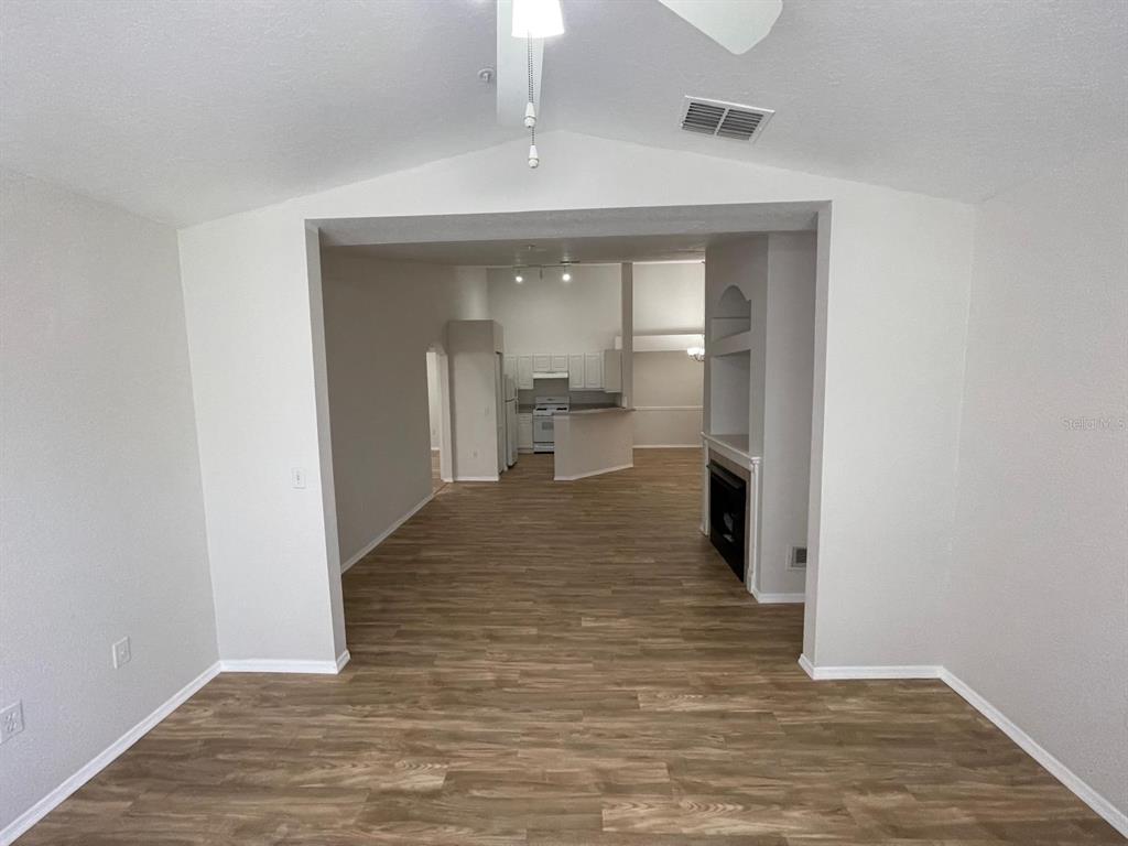 A view from a living area looking toward a kitchen with wood-look flooring — 3313 S KIRKMAN ROAD UNIT 220, ORLANDO, FL