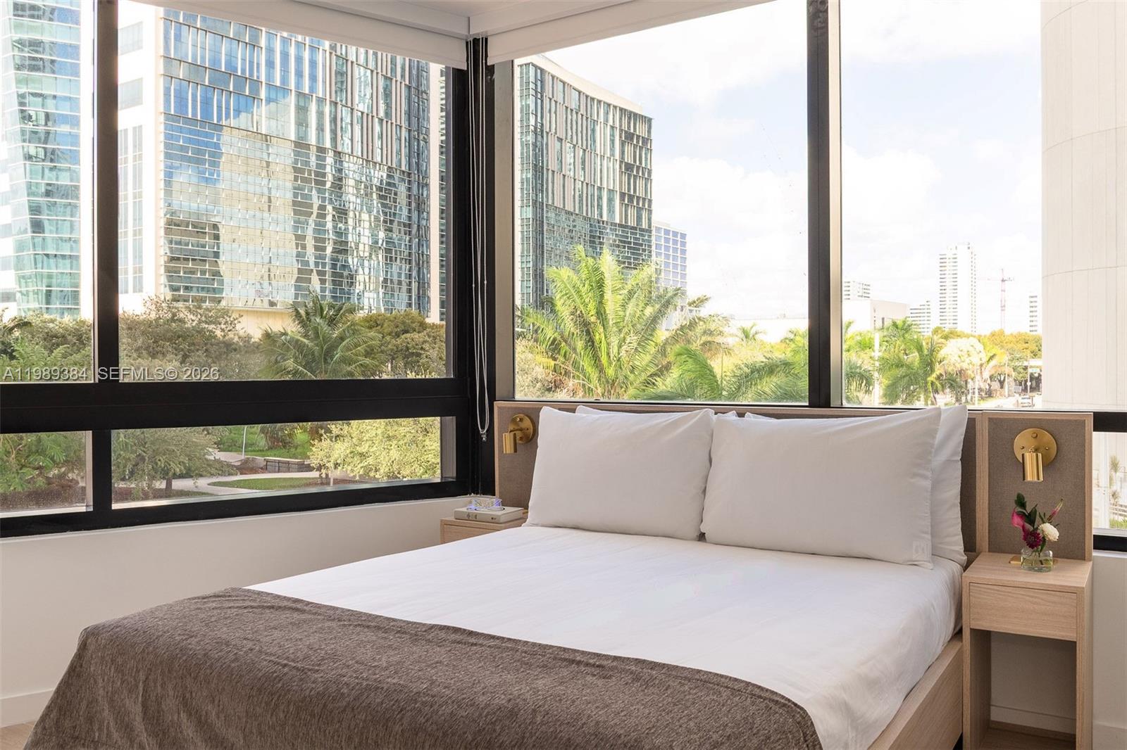 A modern kitchen features light wood cabinetry, a stainless steel oven, and a white countertop — 225 N Miami Ave # 202, Miami FL 33128, MIAMI, FL