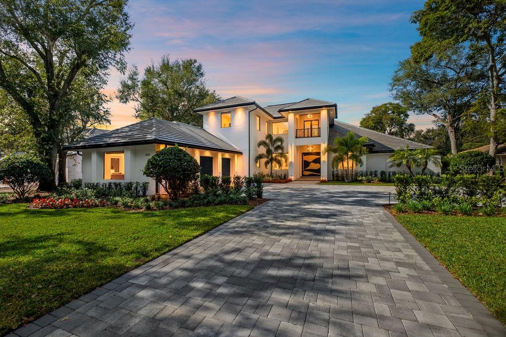 A two-story modern house with a paved driveway, tiled roof, and landscaped front yard — 5074 ISLEWORTH COUNTRY CLUB DRIVE, WINDERMERE, FL