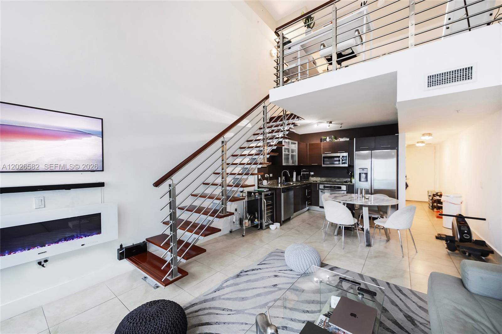 A modern loft apartment features a floating staircase, open kitchen, and a mezzanine level office — 41 SE 5th St # 1303, Miami FL 33131, MIAMI, FL