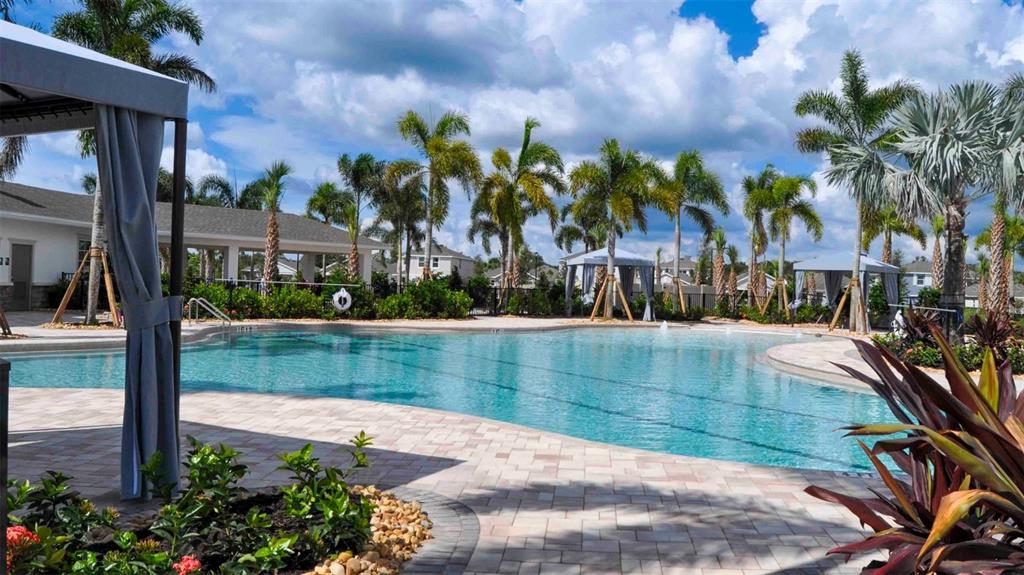 A kitchen features white cabinets, stainless steel appliances, a center island, and wood-look flooring — 17856 WHEAT STACK COURT, PARRISH, FL