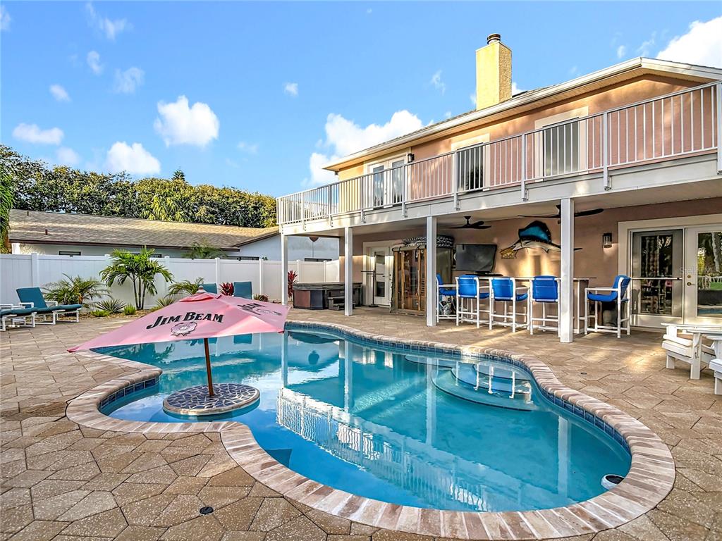 An elevated view of a backyard swimming pool with a red umbrella and patio furniture — 4508 SAXON DRIVE, NEW SMYRNA BEACH, FL