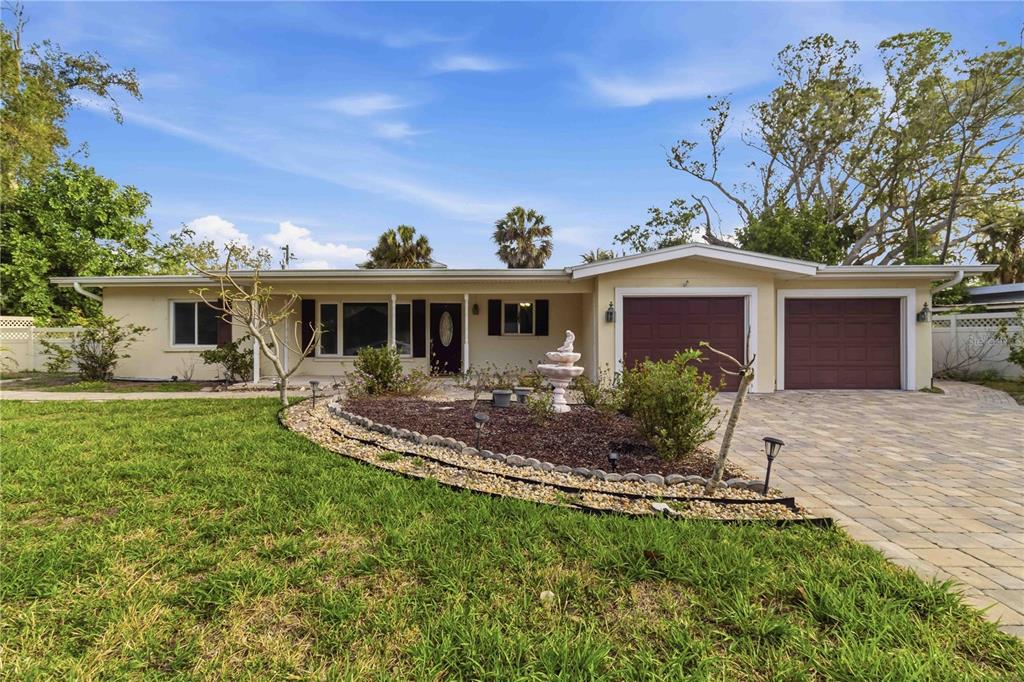 A single-story house with a two-car garage, a paved driveway, and a landscaped front yard — 617 CALLE DE PERU, SARASOTA, FL