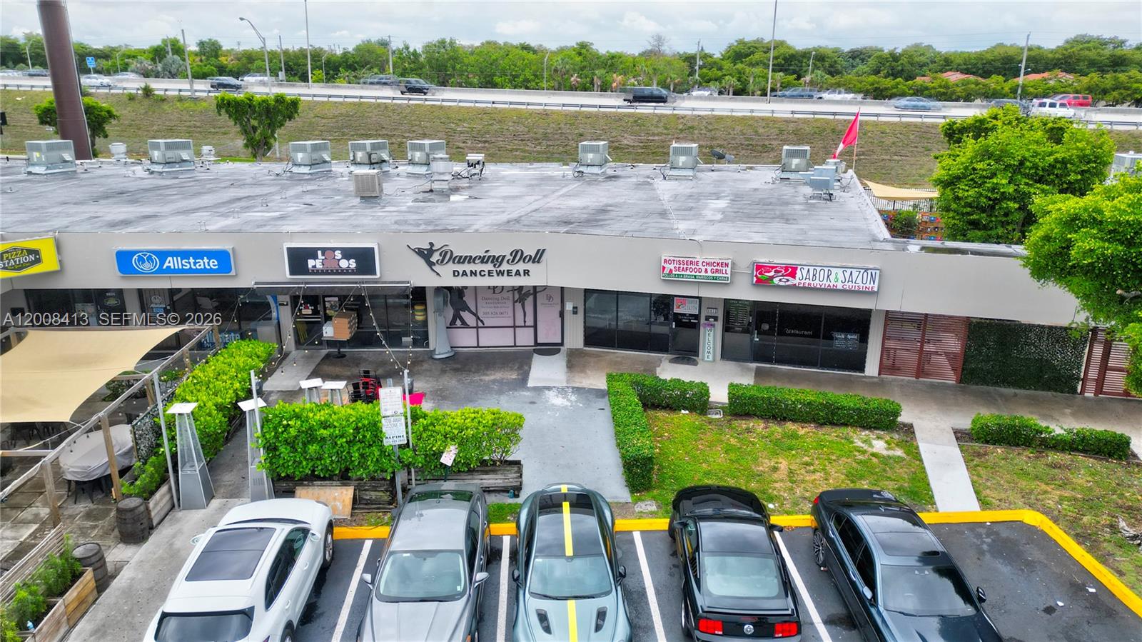 An aerial view shows a strip mall with several storefronts and a parking lot — 68 169 ST, Hialeah FL 33015, HIALEAH, FL