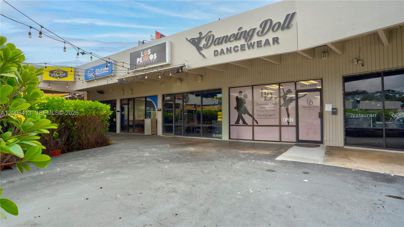The exterior of a commercial strip mall features storefronts for a dancewear shop and restaurant — 68 169 ST, Hialeah FL 33015, HIALEAH, FL