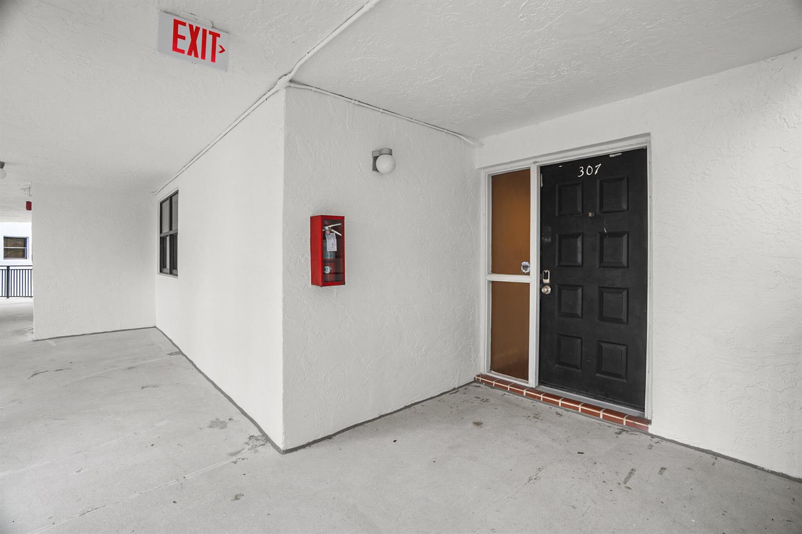 A black apartment door numbered 307 is located in a white outdoor hallway — 16141 Blatt Boulevard # 307, Weston FL 33326, WESTON, FL