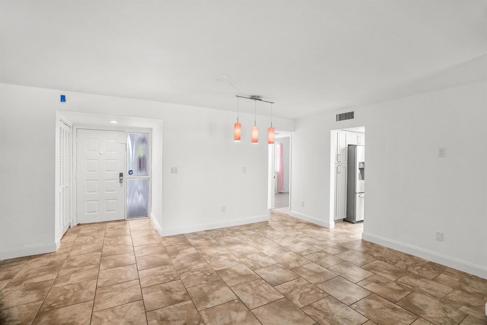 An open dining area features tan tile flooring, white walls, and a three-light pendant fixture — 16141 Blatt Boulevard # 307, Weston FL 33326, WESTON, FL