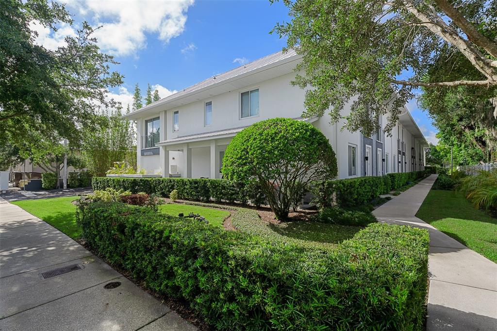 A two-story white building with a metal roof, manicured hedges, and a concrete walkway — 436 W SWOOPE AVENUE, WINTER PARK, FL