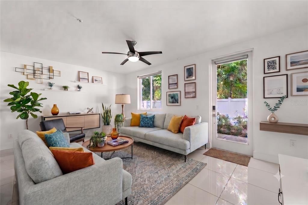 A bright living room features two light gray sofas, a round coffee table, and a door — 436 W SWOOPE AVENUE, WINTER PARK, FL