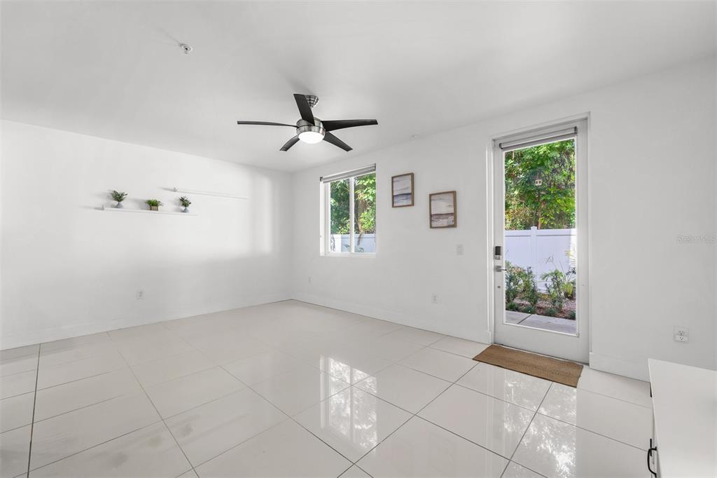 A bright, minimalist room features white walls, large glossy floor tiles, and a ceiling fan — 436 W SWOOPE AVENUE, WINTER PARK, FL