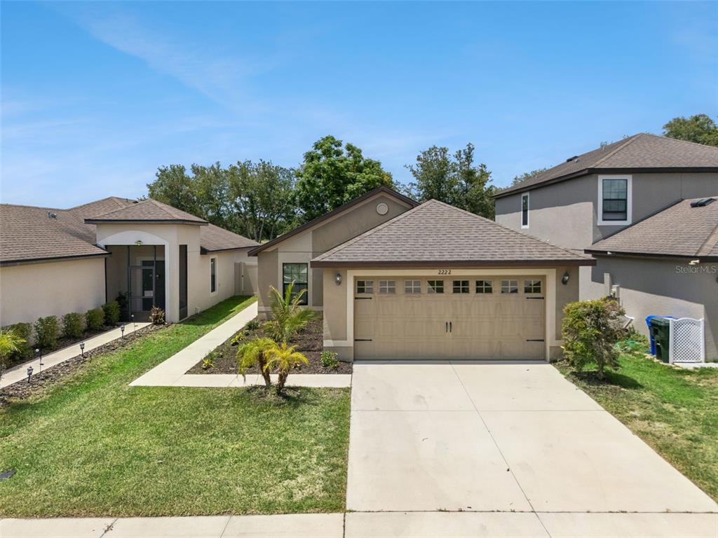A single-story suburban house with a two-car garage and a concrete driveway — 2222 CASPIAN DRIVE, LAKELAND, FL