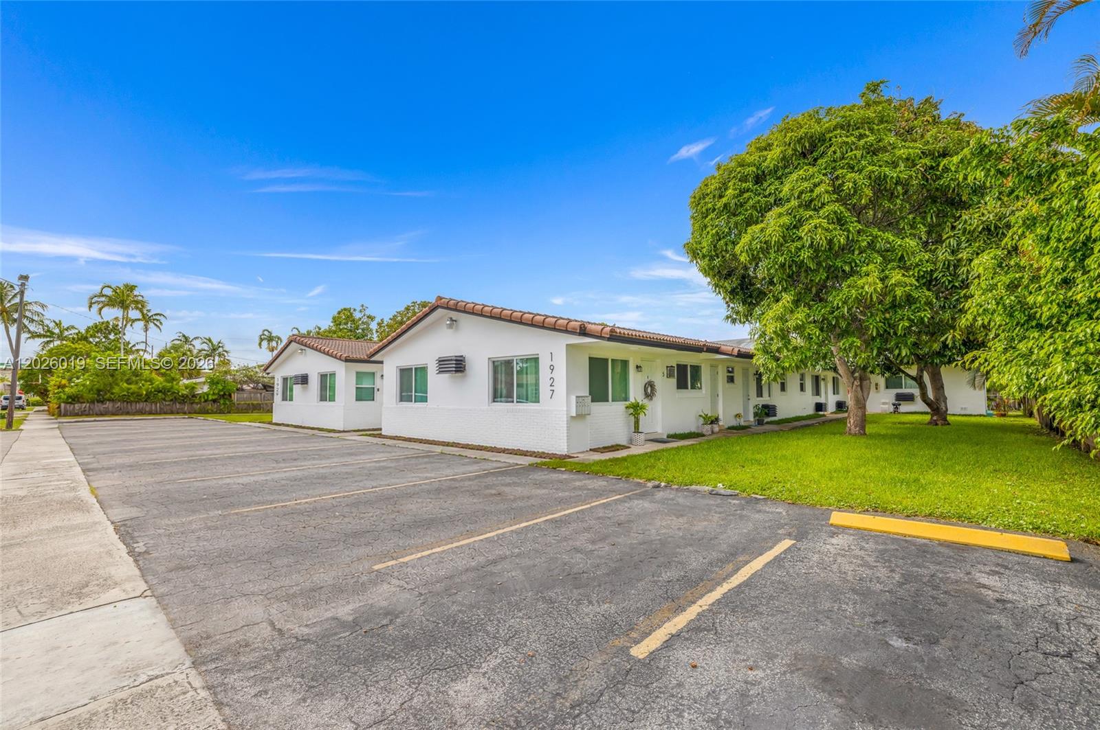A single-story white apartment building with a parking lot and a large tree — 1927/1929 Roosevelt St, Hollywood FL 33020, HOLLYWOOD, FL