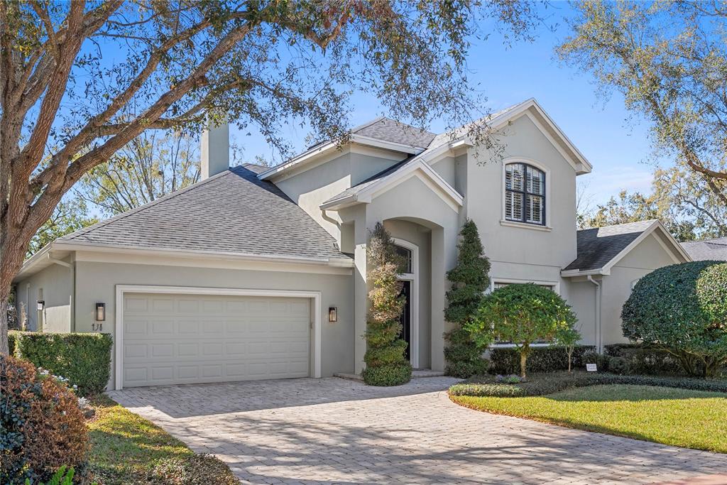 A two-story house with a light-colored stucco exterior, a paved driveway, and a two-car garage — 438 HARBOUR OAKS POINTE DRIVE, ORLANDO, FL