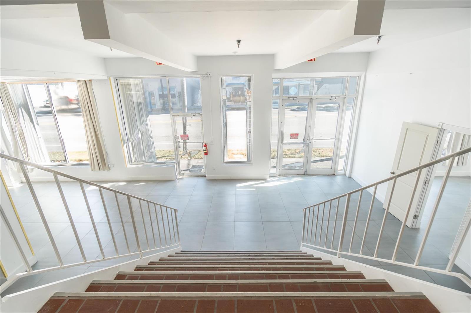 A view from a staircase looking down into a bright commercial space with tile flooring — 49 N Federal Highway, Dania Beach FL 33004, DANIA BEACH, FL