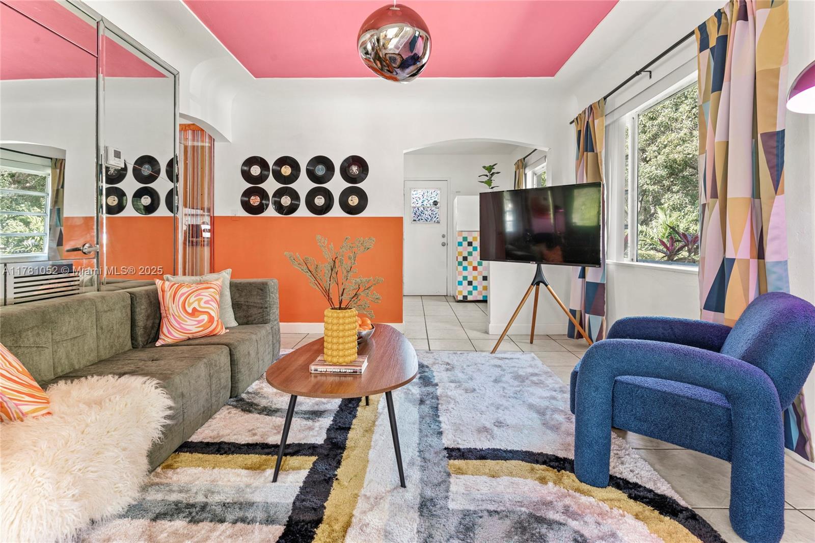 A living room features a pink ceiling, orange wall accents, vinyl records, and colorful decor — 260 NE 45th St, Miami FL 33137, MIAMI, FL