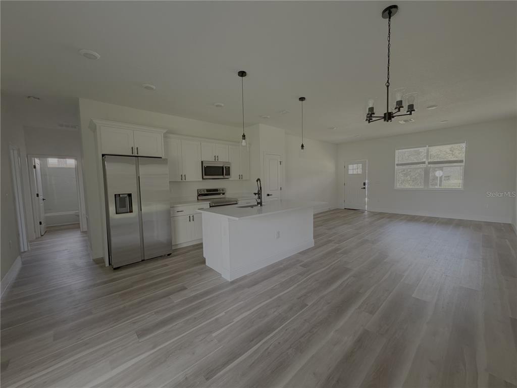 A kitchen with white cabinets, stainless steel appliances, and a central island with a sink — 1852 W QUAKER LANE, CITRUS SPRINGS, FL