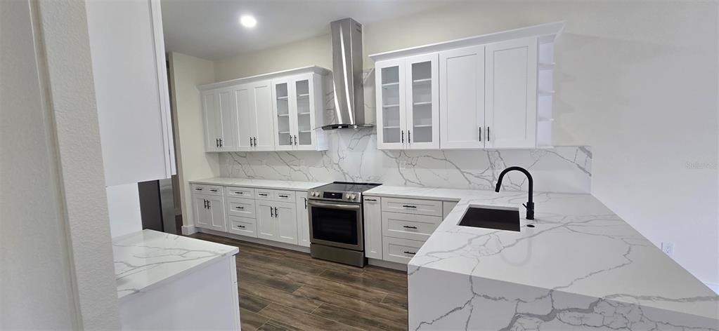 A modern kitchen features white cabinets, stainless steel appliances, and white marble-patterned quartz countertops — 20016 OAKFLOWER AVENUE, TAMPA, FL