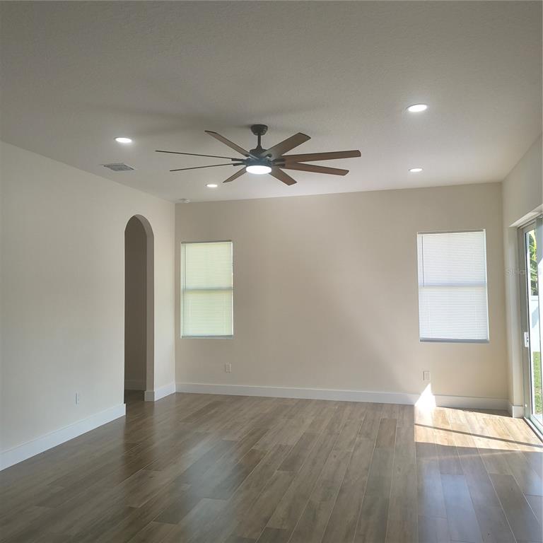 A modern kitchen features white cabinets, quartz countertops with gray veining, and stainless steel appliances — 20016 OAKFLOWER AVENUE, TAMPA, FL