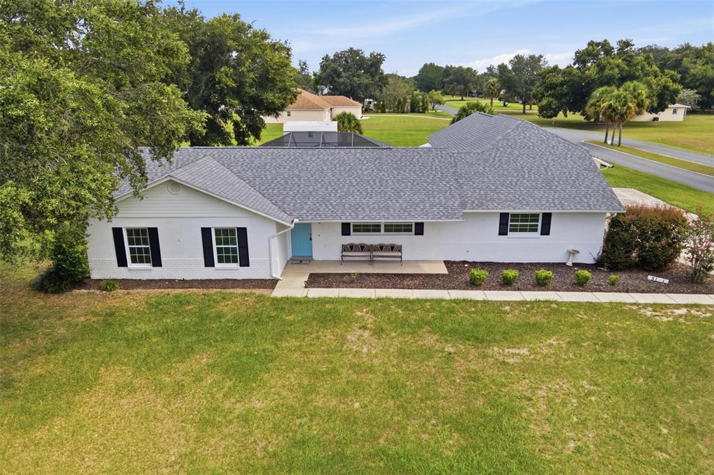 An aerial view of a white, single-story house with a gray shingled roof and shutters — 5101 LAKE GRIFFIN ROAD, LADY LAKE, FL