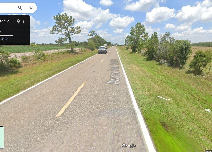 A paved road stretches through a rural landscape with trees and open fields under a sky — AVON PARK CUTOFF ROAD, FROSTPROOF, FL