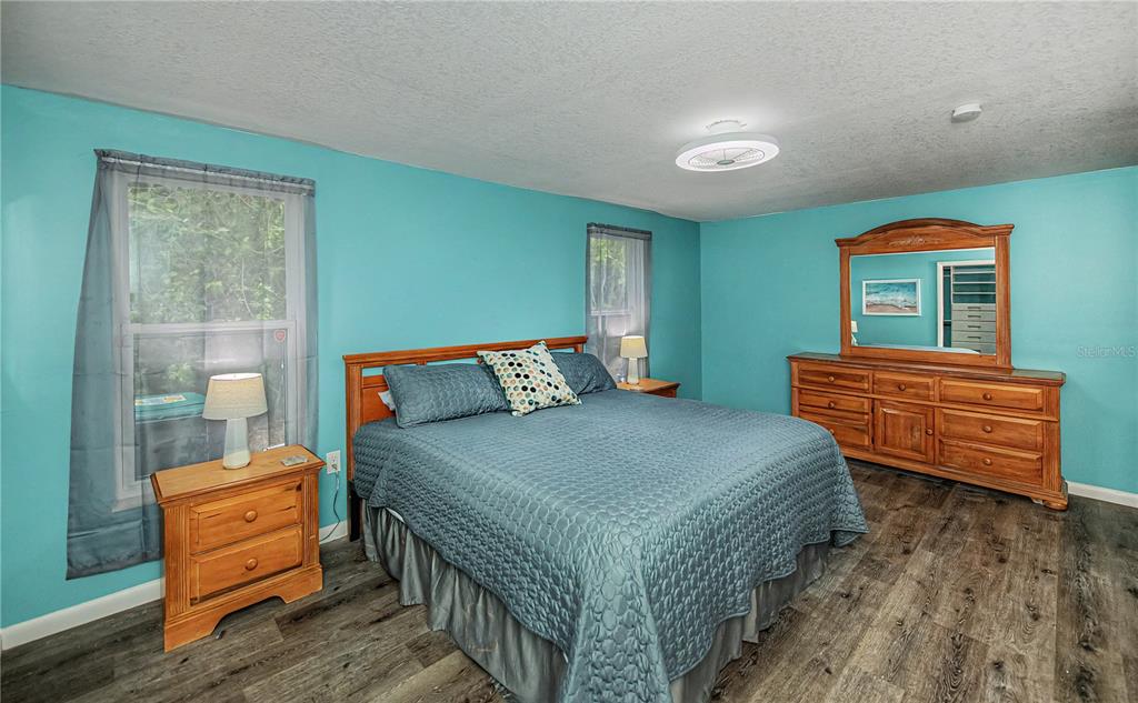 A bedroom with turquoise walls, wood-look flooring, a wooden bed frame, and a matching dresser — 1443 ABSCOTT STREET, PORT CHARLOTTE, FL