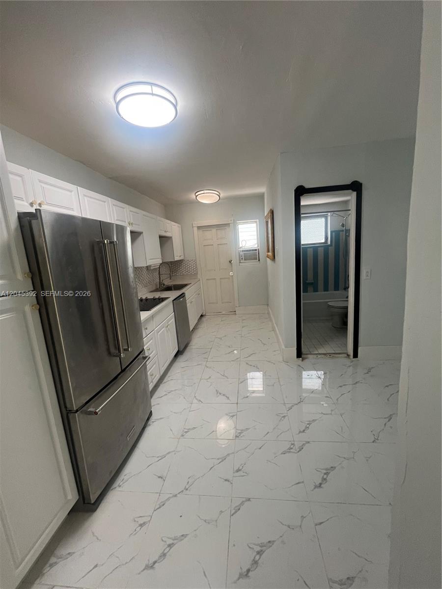 A kitchen with white cabinets, stainless steel appliances, and white marble-patterned tile flooring — 636 Meridian Ave # 4, Miami Beach FL 33139, MIAMI BEACH, FL