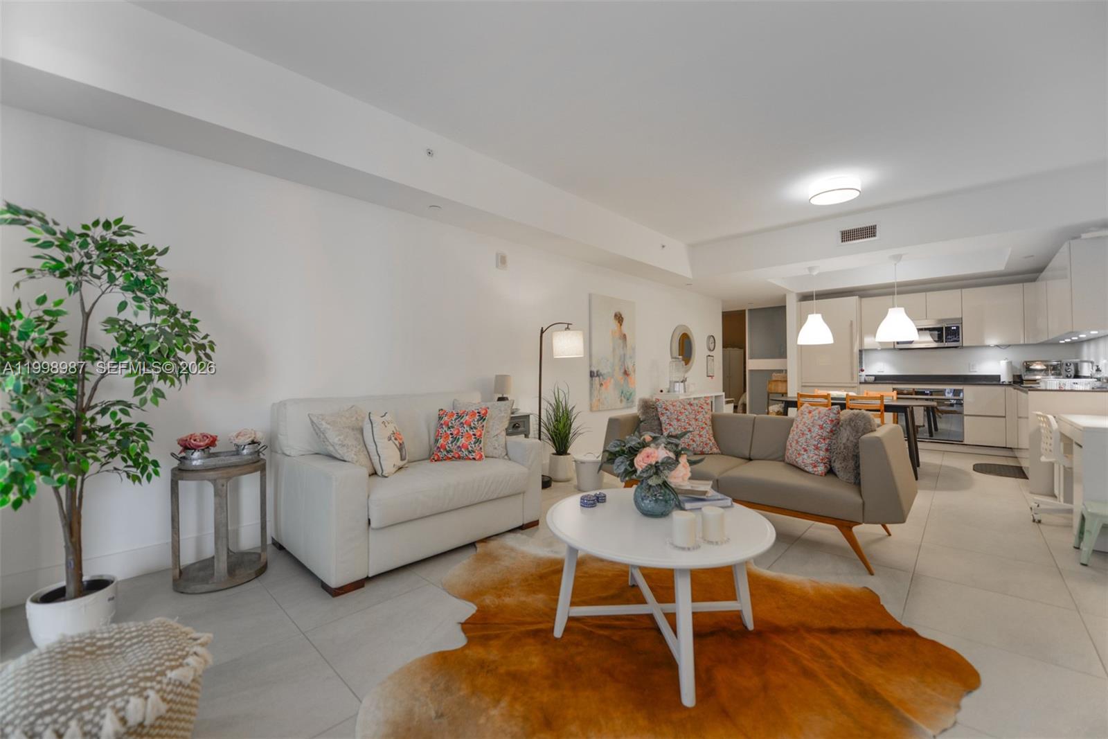 A living room features a white sofa, a grey sofa, and a cowhide area rug — 1010 Brickell Ave # 2906, Miami FL 33131, MIAMI, FL