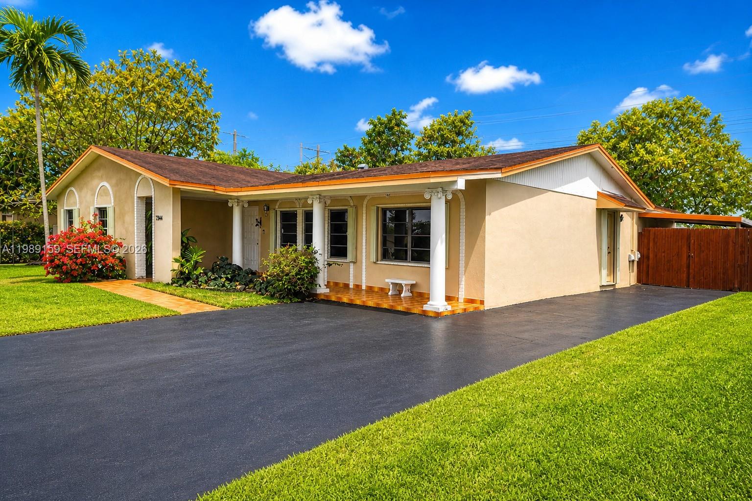 A single-story house with a tan exterior, a covered porch with columns, and a driveway — 7344 SW 135th Ct, Miami FL 33183, MIAMI, FL