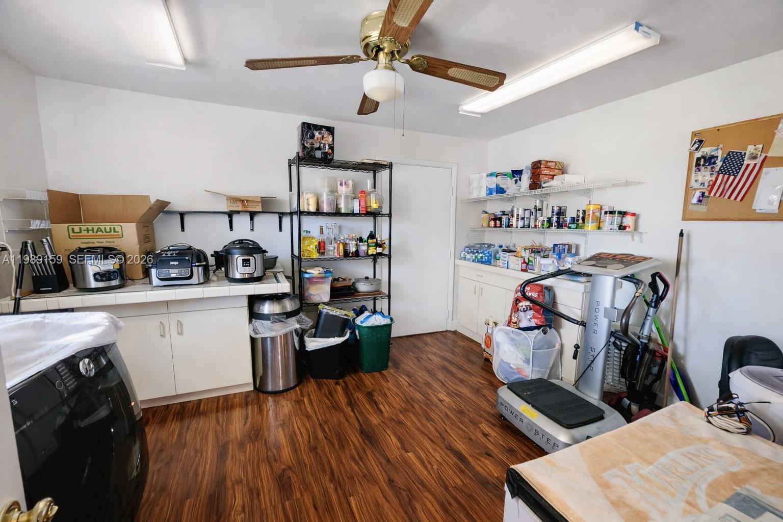 A utility room with wood-look flooring, white cabinets, open shelving, and a ceiling fan — 7344 SW 135th Ct, Miami FL 33183, MIAMI, FL