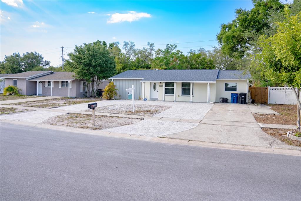 A single-story house with a paved driveway, light-colored siding, and a dark shingled roof — 2908 EDENWOOD STREET, CLEARWATER, FL