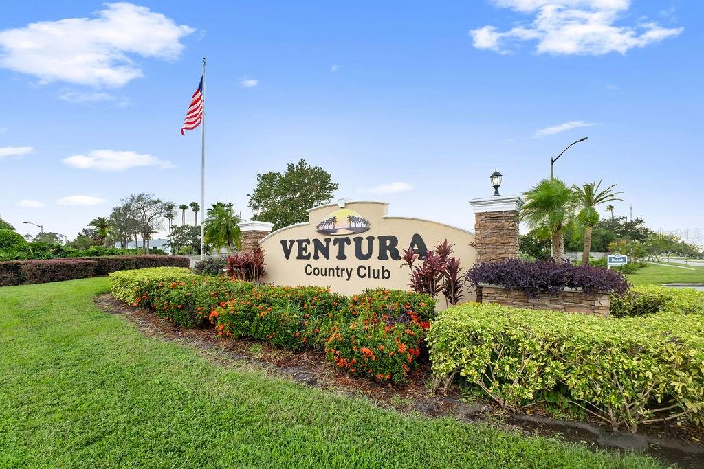A sign for Ventura Country Club stands in a landscaped garden with an American flag — 3998 ATRIUM DRIVE UNIT U-1, ORLANDO, FL