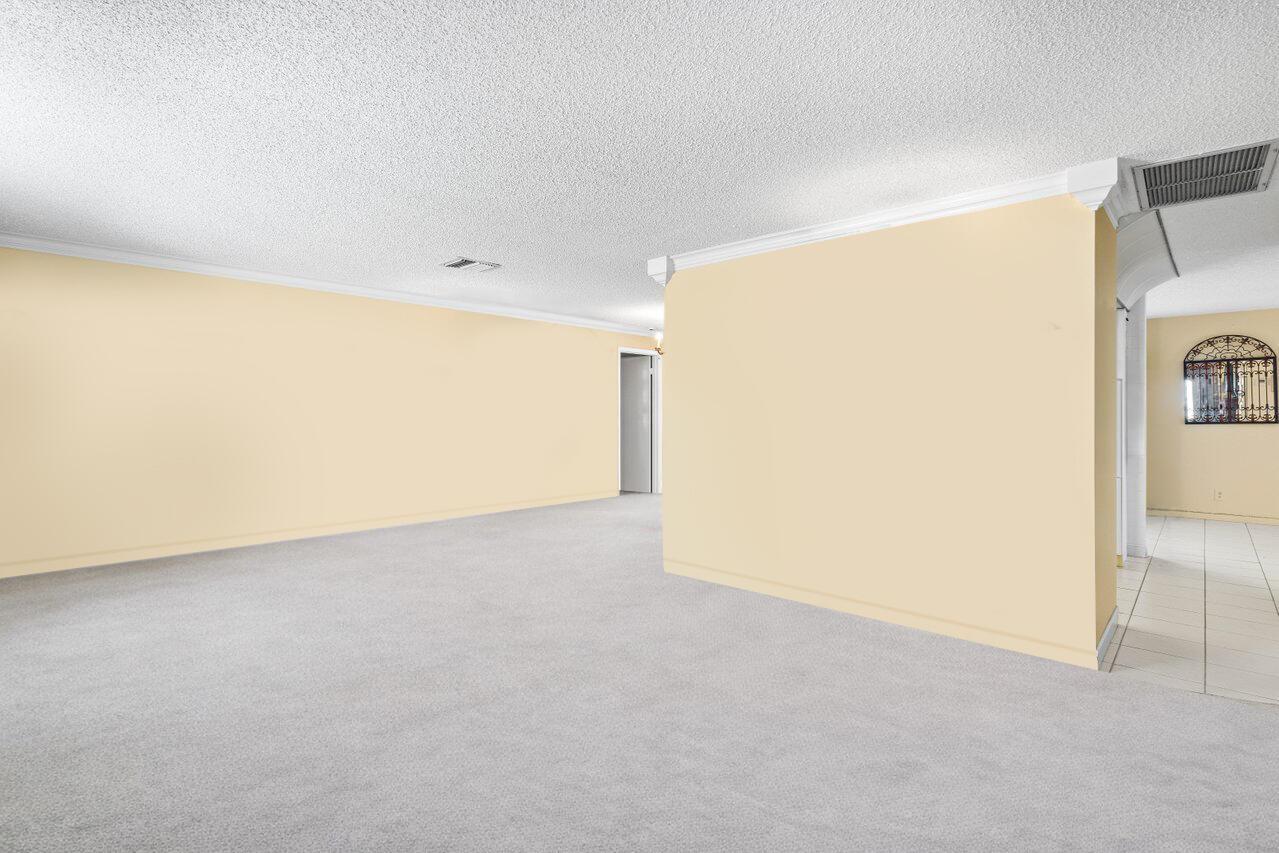 An empty room with light yellow walls, gray carpeting, and a white ceiling — 1802 SW 13th Avenue, Boynton Beach FL 33426, BOYNTON BEACH, FL