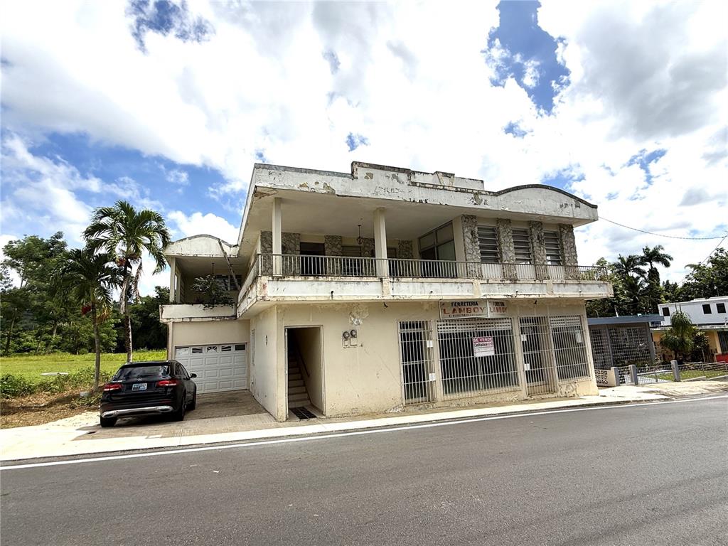 A two-story commercial building with a garage, balcony, and metal security grates on the facade — 12 HOSTOS CABRERA ST., SAN SEBASTIAN, PR