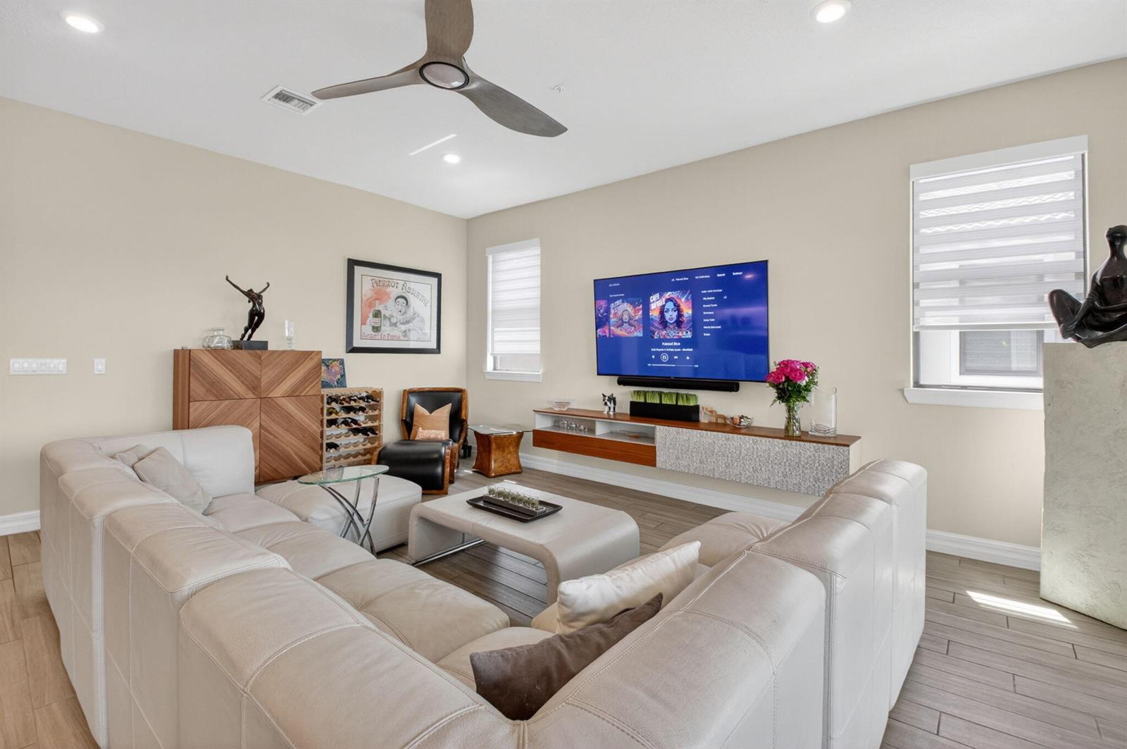 A living room features a large sectional sofa, a wall-mounted television, and wood-look tile flooring — 21956 Canadensis Circle # 201, Boca Raton FL 33428, BOCA RATON, FL